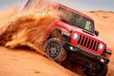 red jeep wrangler off roading in the desert