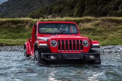 red jeep wrangler driving through water